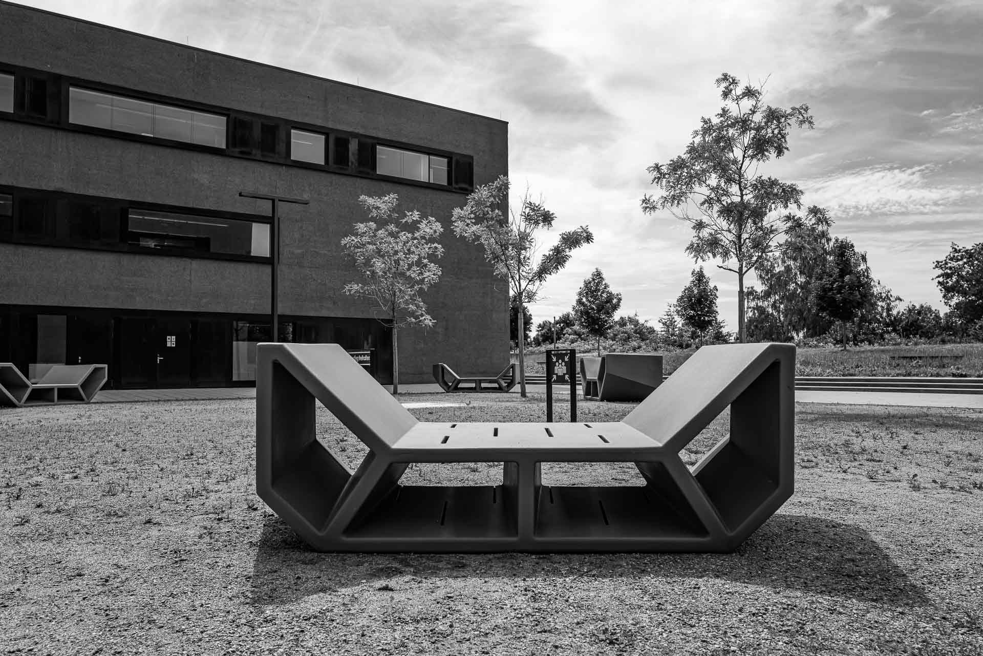 leere Bänke vor einem Campusgebäude