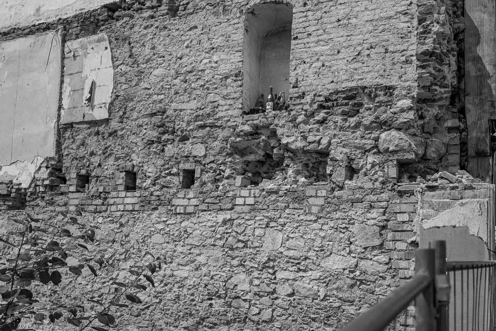 durch den Abriss eine Gebäudes erscheinen die Weinflaschen in einer Mauernische