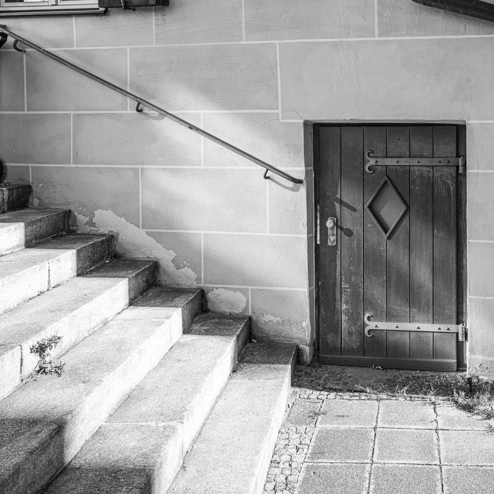 eine weitere kleine Tür in einer Mauer.Links geht es eine Treppe hinauf.